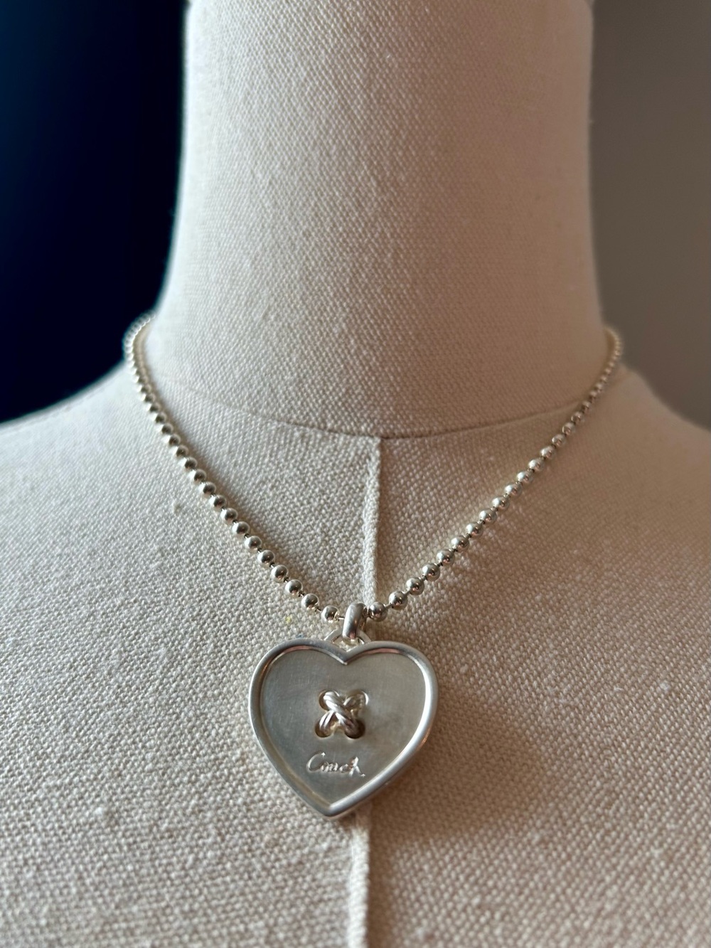 Coach Sterling Silver Heart Pendant Necklace with engraved logo.
